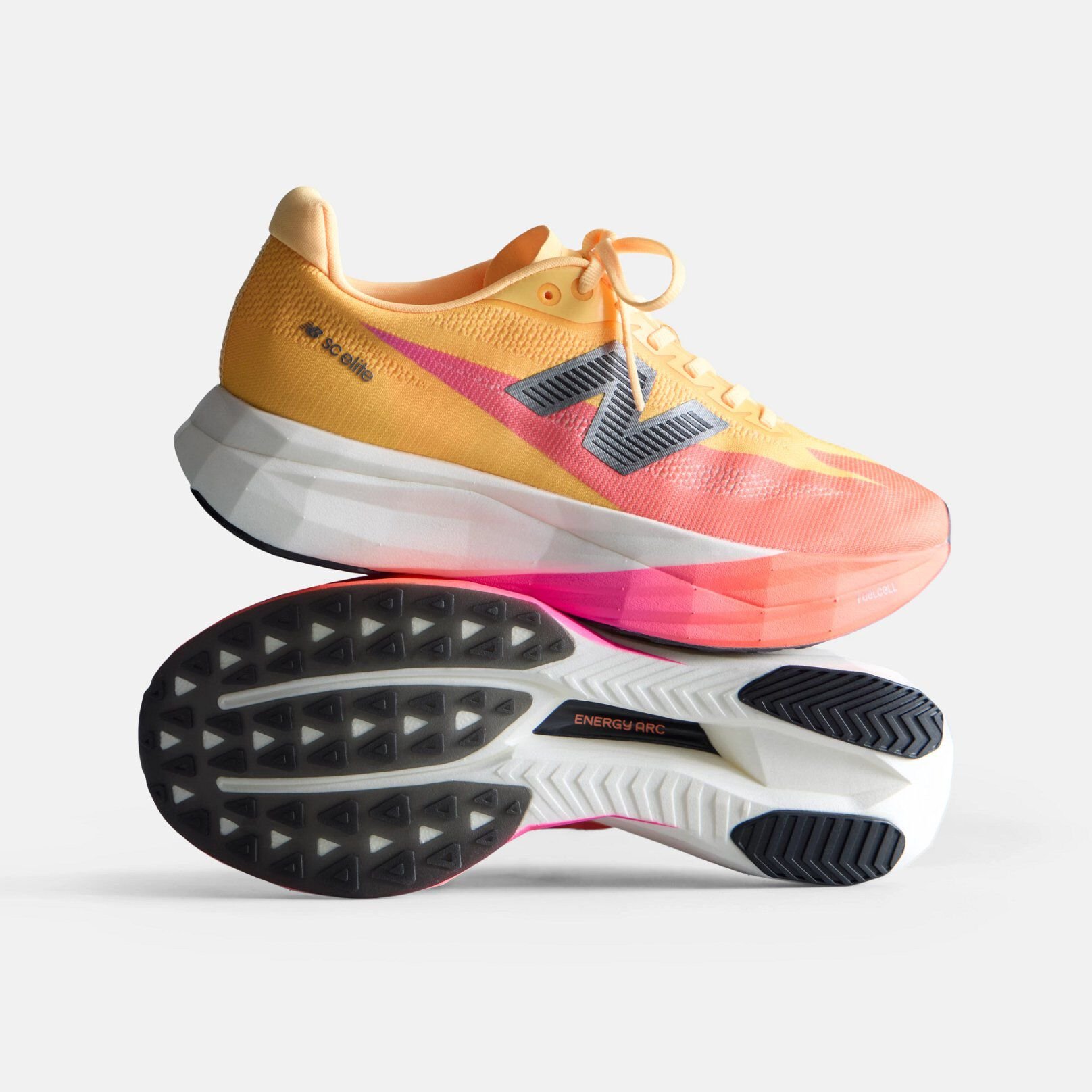 Orange and peach running shoe with a white midsole and black New Balance logo on a white background. 